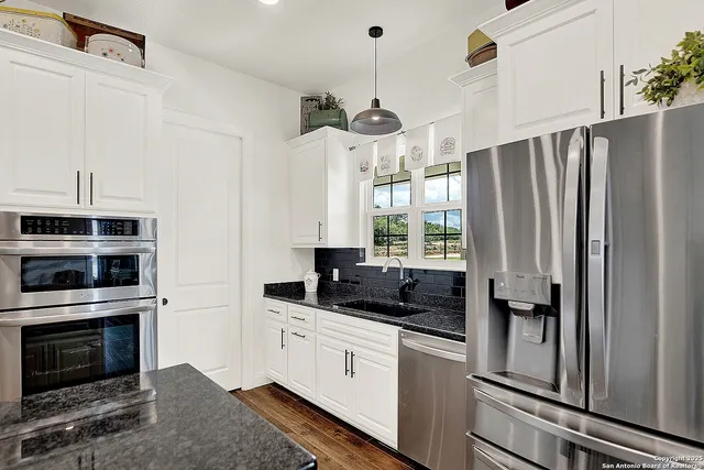 a kitchen with stainless steel appliances a refrigerator sink and microwave