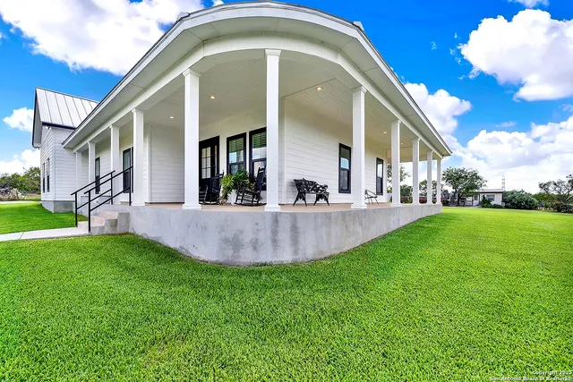 a view of a house with a backyard porch and sitting area