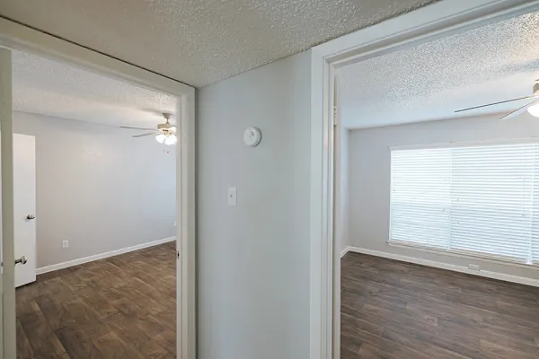 an empty room with a window and a fan