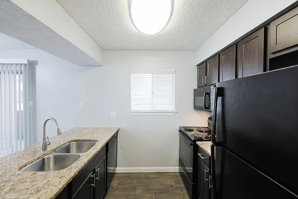 a kitchen that has a sink cabinets counter space and appliances