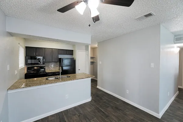 a room with kitchen island a sink and wooden floor