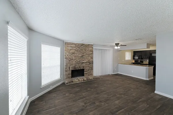 a view of empty room with wooden floor and fireplace