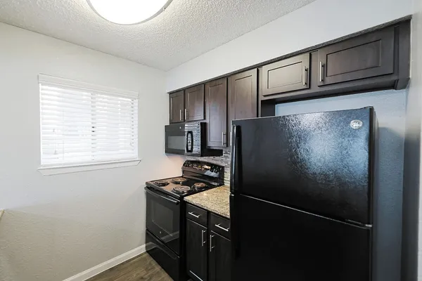 a kitchen with a refrigerator and a stove top oven
