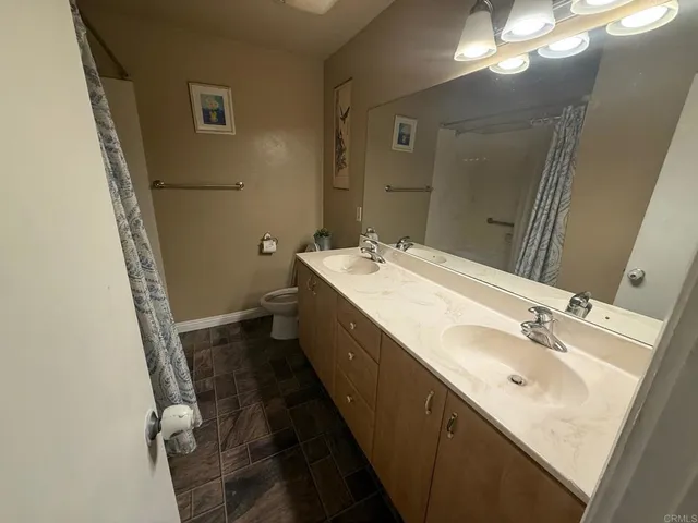 a bathroom with a double vanity sink and a mirror