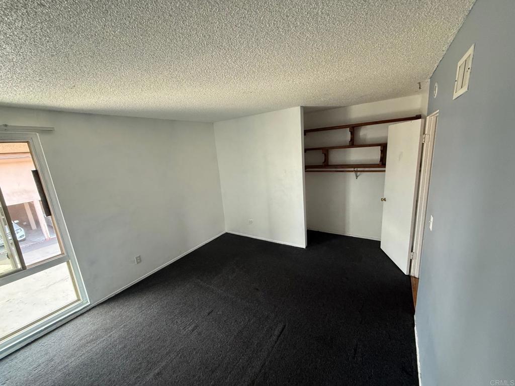 525 Shady Lane, Unit D El Cajon, CA 92021 - Photo 15 of 41 an empty room with wooden floor cabinet and windows