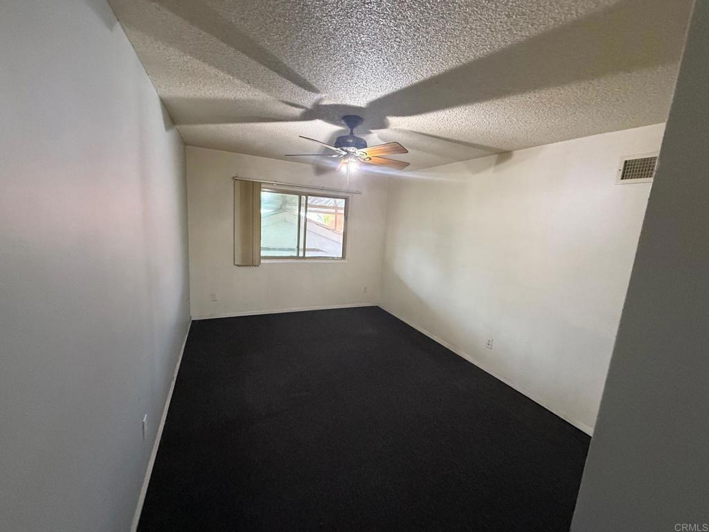 525 Shady Lane, Unit D El Cajon, CA 92021 - Photo 8 of 41 an empty room with windows and fan
