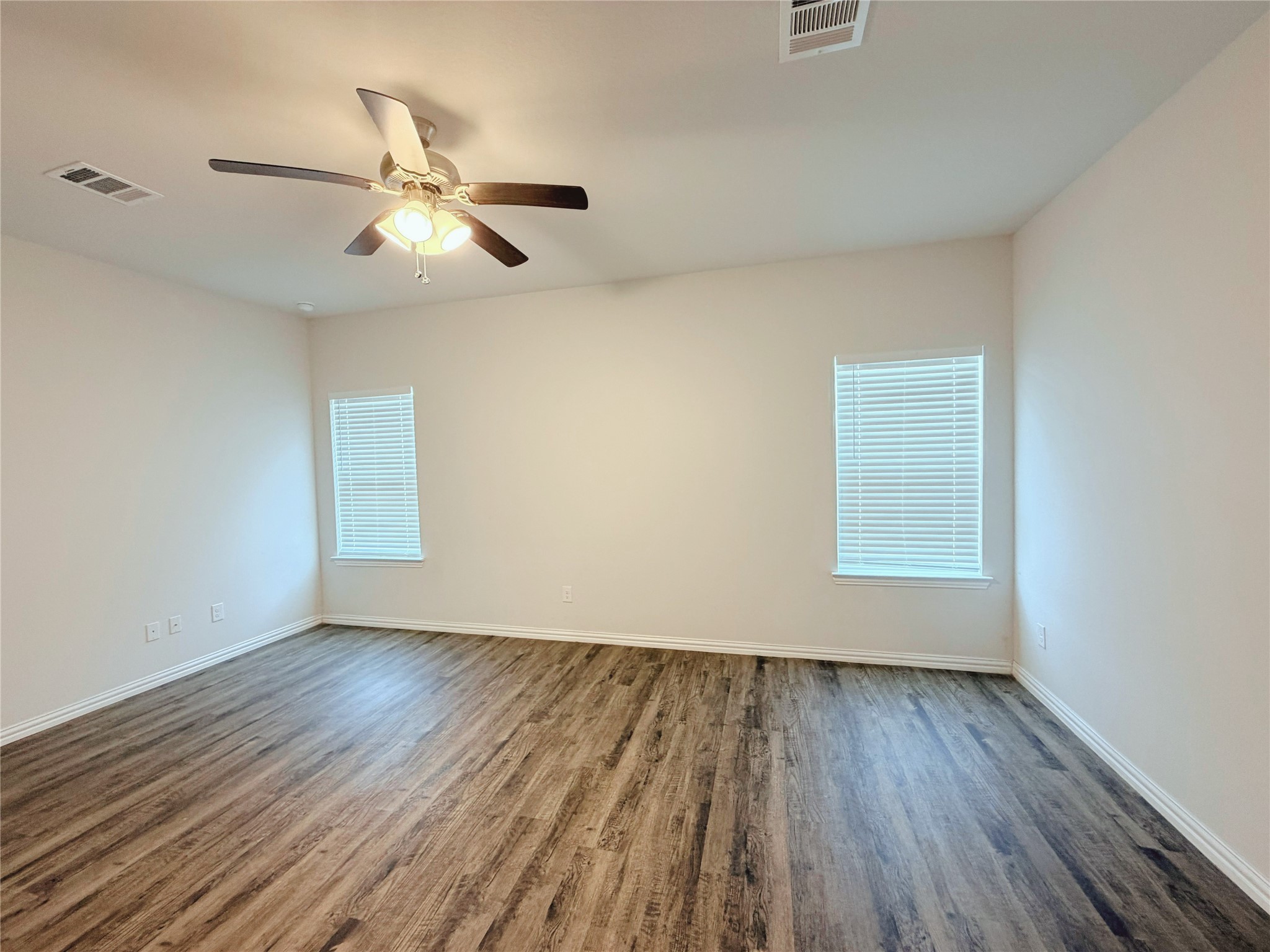 870 5102nd Road Cleveland, TX 77327 - Photo 17 of 27 an empty room with wooden floor fan and windows