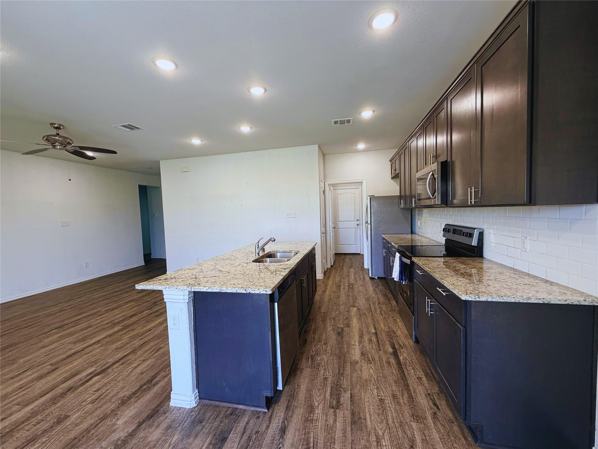 870 5102nd Road Cleveland, TX 77327 - Photo 5 of 27 a kitchen with granite countertop a sink stove and cabinets