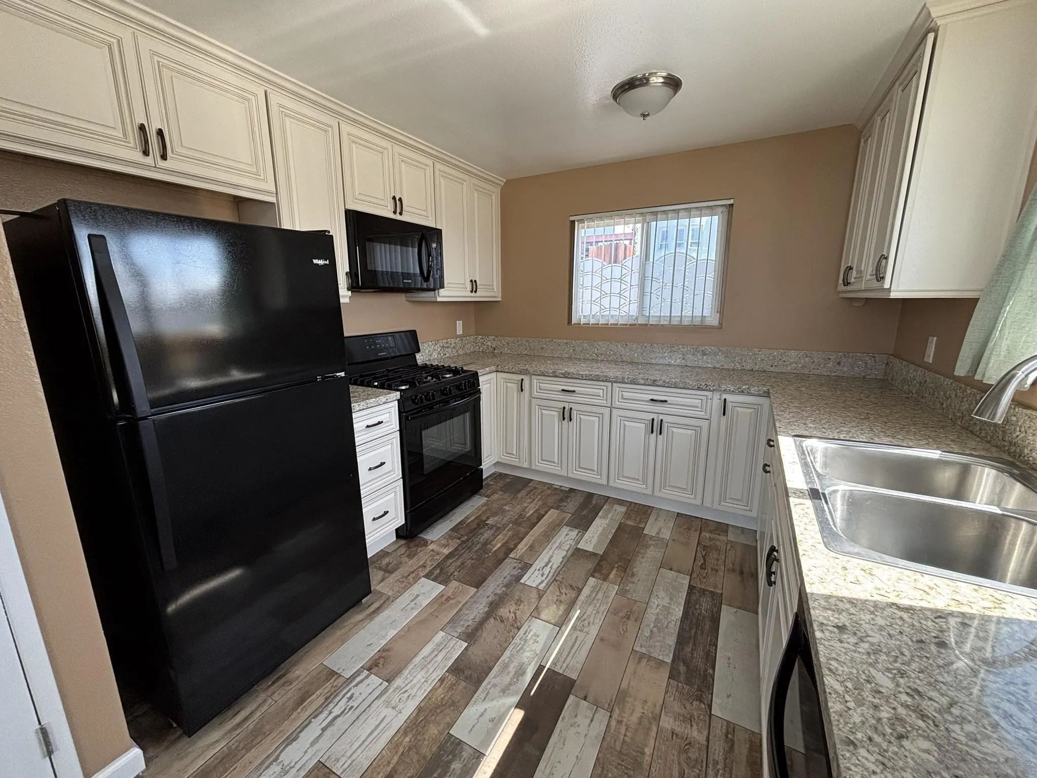 514 South The Strand, Unit D Oceanside, CA 92054 - Photo 11 of 18 a kitchen with granite countertop stainless steel appliances a stove sink and microwave