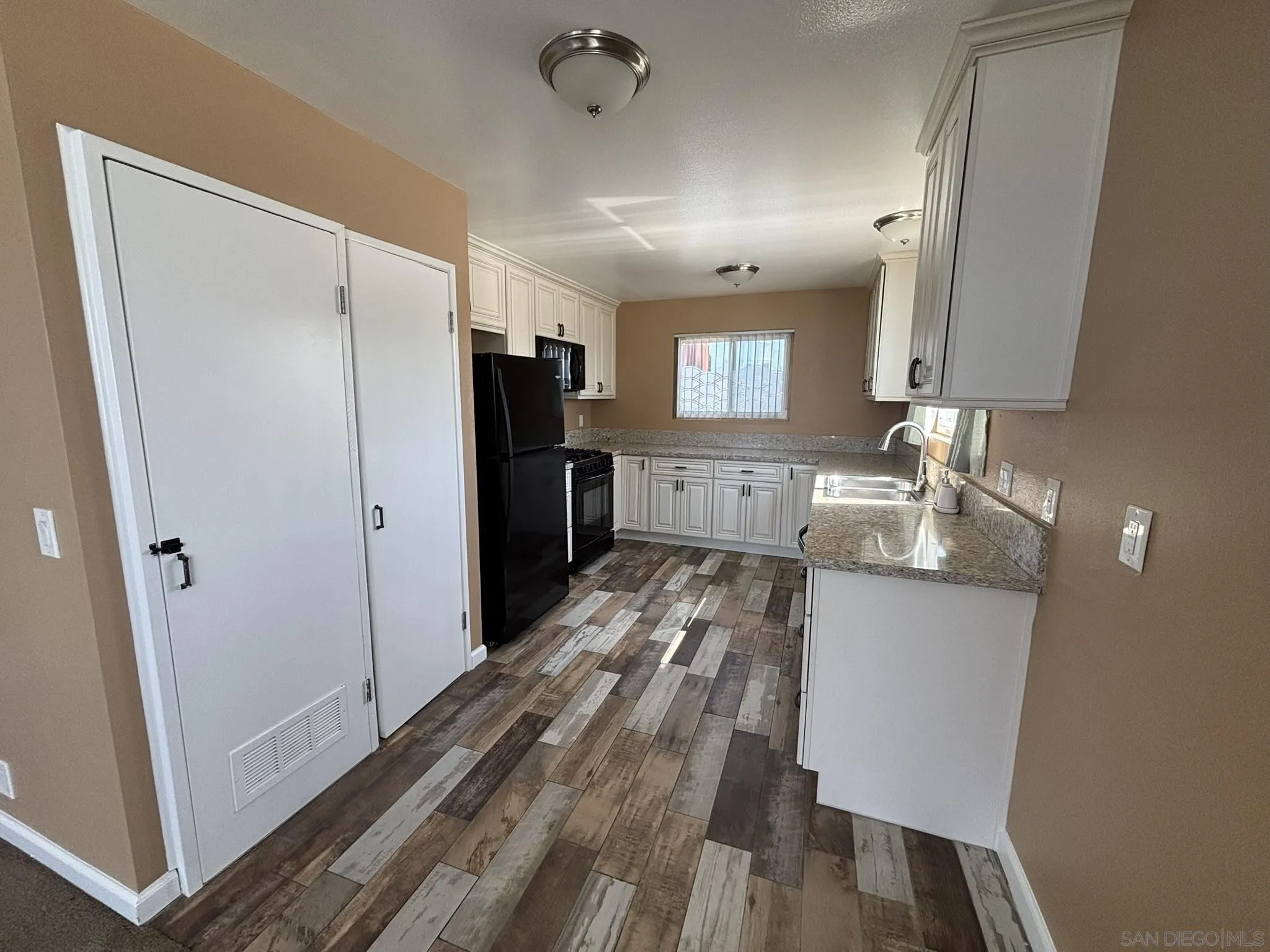 514 South The Strand, Unit D Oceanside, CA 92054 - Photo 9 of 18 a kitchen with granite countertop a refrigerator and a sink