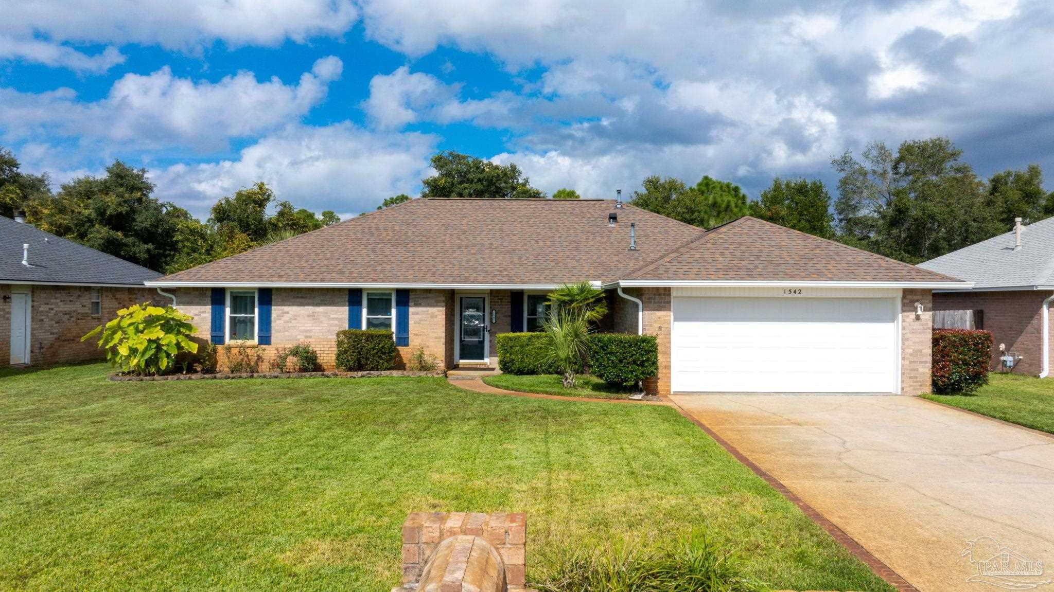 a view of a white house with a big yard and large trees