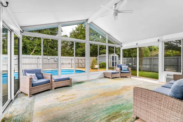 a living room with furniture and floor to ceiling windows