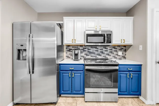 a kitchen with kitchen island a sink stainless steel appliances and cabinets