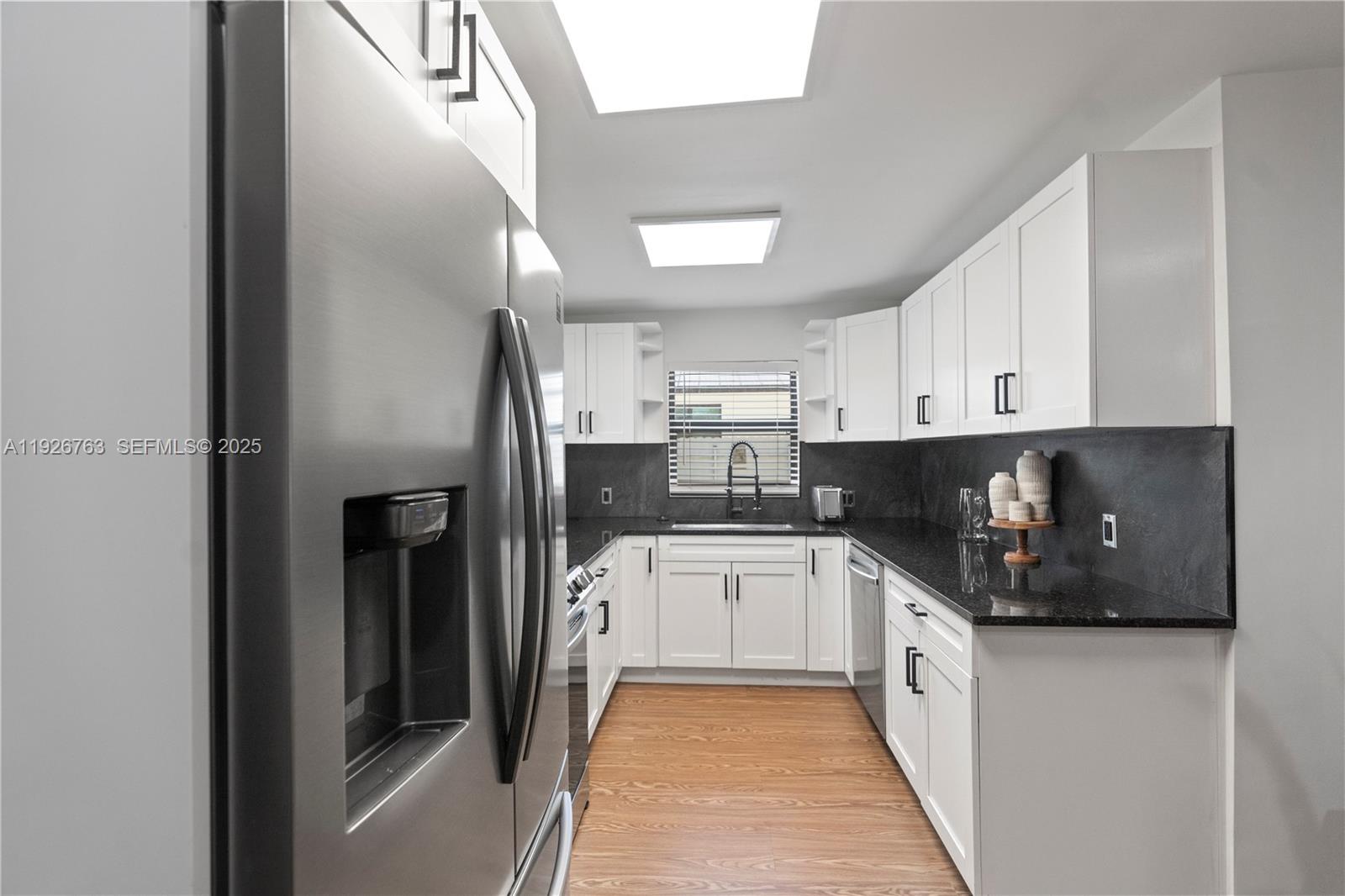 601 Southwest 1st Street Hallandale Beach, FL 33009 - Photo 12 of 33 a kitchen with stainless steel appliances a refrigerator sink and cabinets