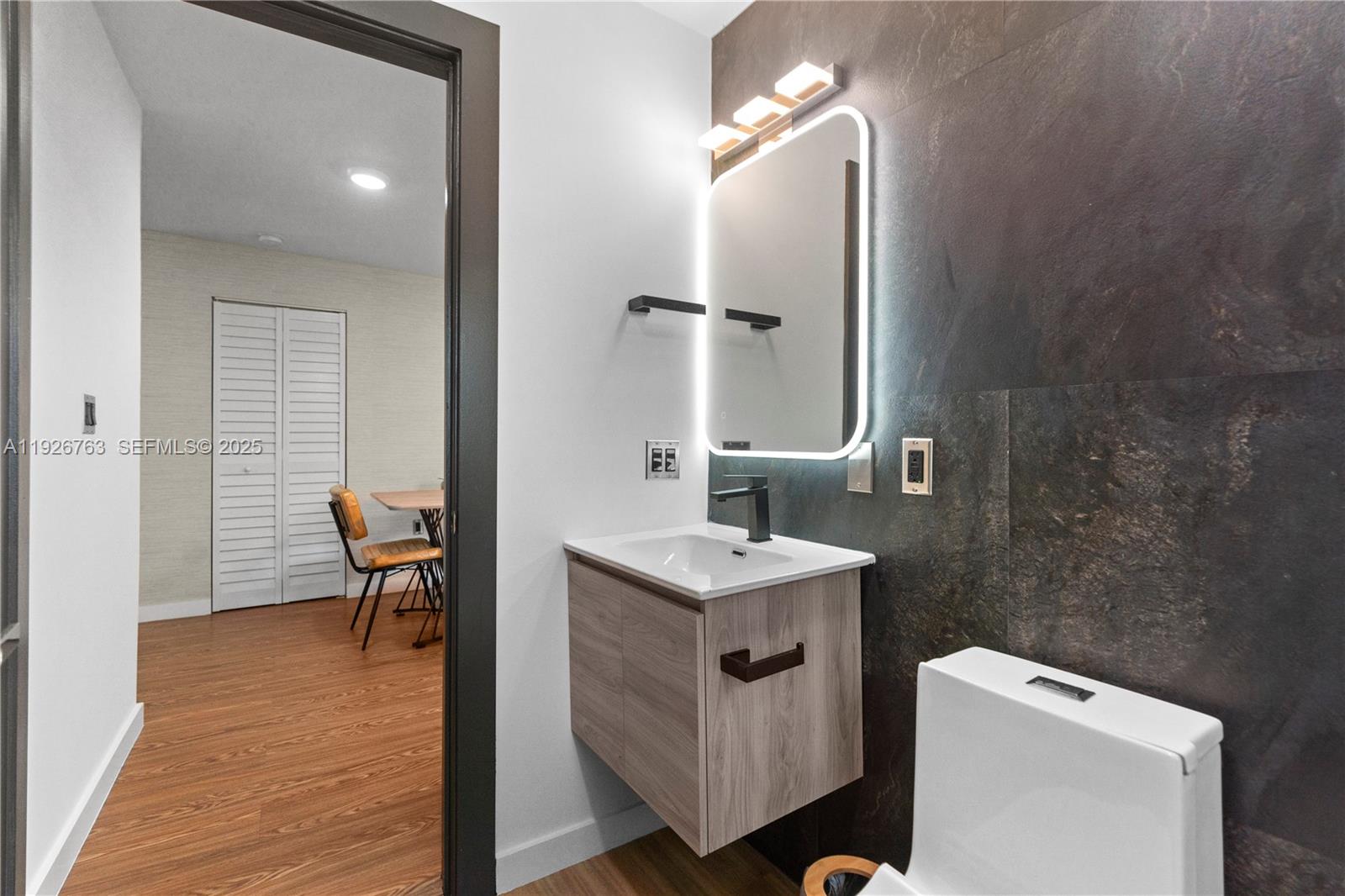 601 Southwest 1st Street Hallandale Beach, FL 33009 - Photo 24 of 33 a en suite bathroom with a granite countertop sink a mirror and a toilet