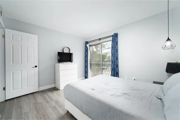 a bedroom with a bed and a flat tv screen on the dresser