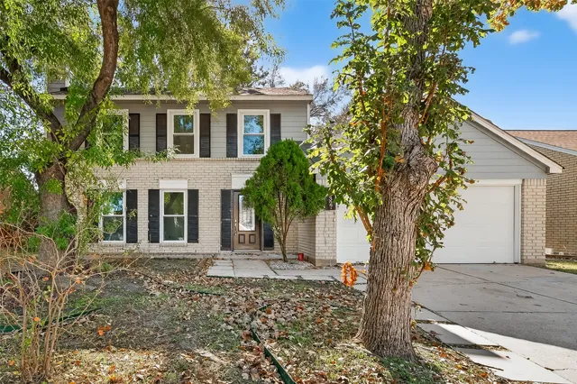a front view of a house with a tree