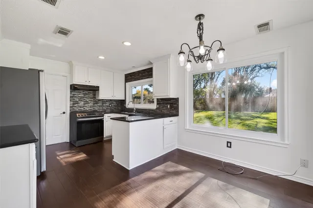 a kitchen with stainless steel appliances white cabinets and a refrigerator