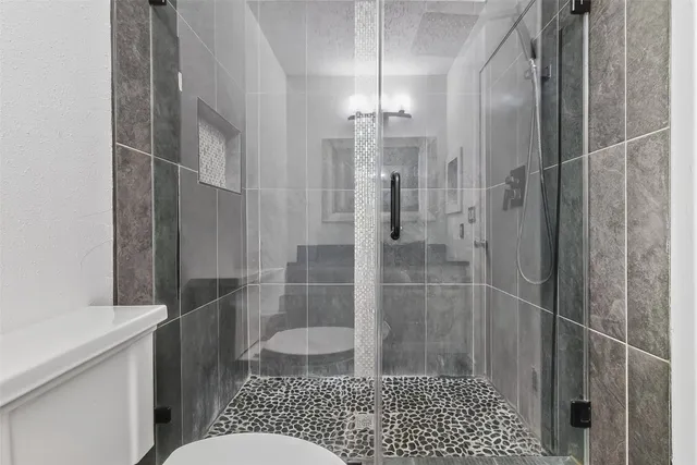 an empty room with wooden floor chandelier fan and windows