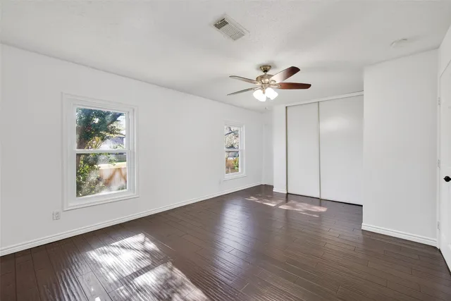 a view of an empty room with wooden floor