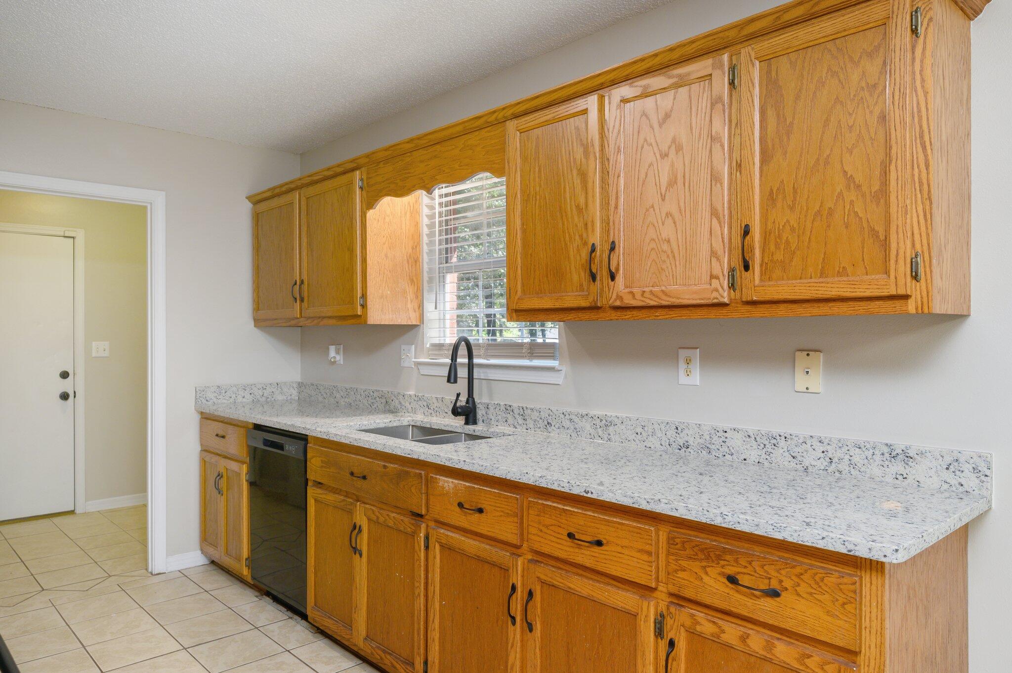 502 Hyde Park Drive Crestview, FL 32539 - Photo 12 of 35 a kitchen with stainless steel appliances granite countertop a sink and cabinets with wooden floor