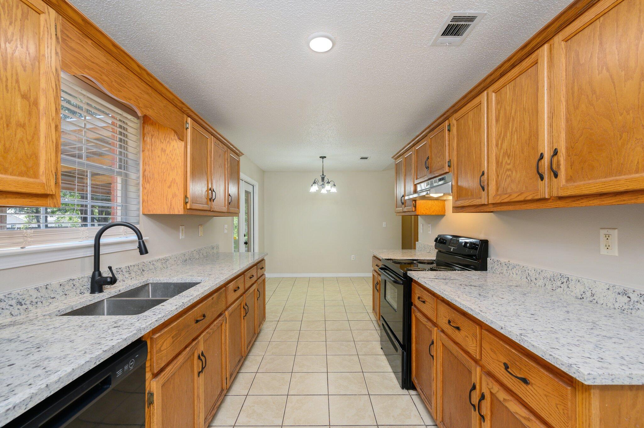 502 Hyde Park Drive Crestview, FL 32539 - Photo 15 of 35 a kitchen with stainless steel appliances granite countertop a sink and cabinets