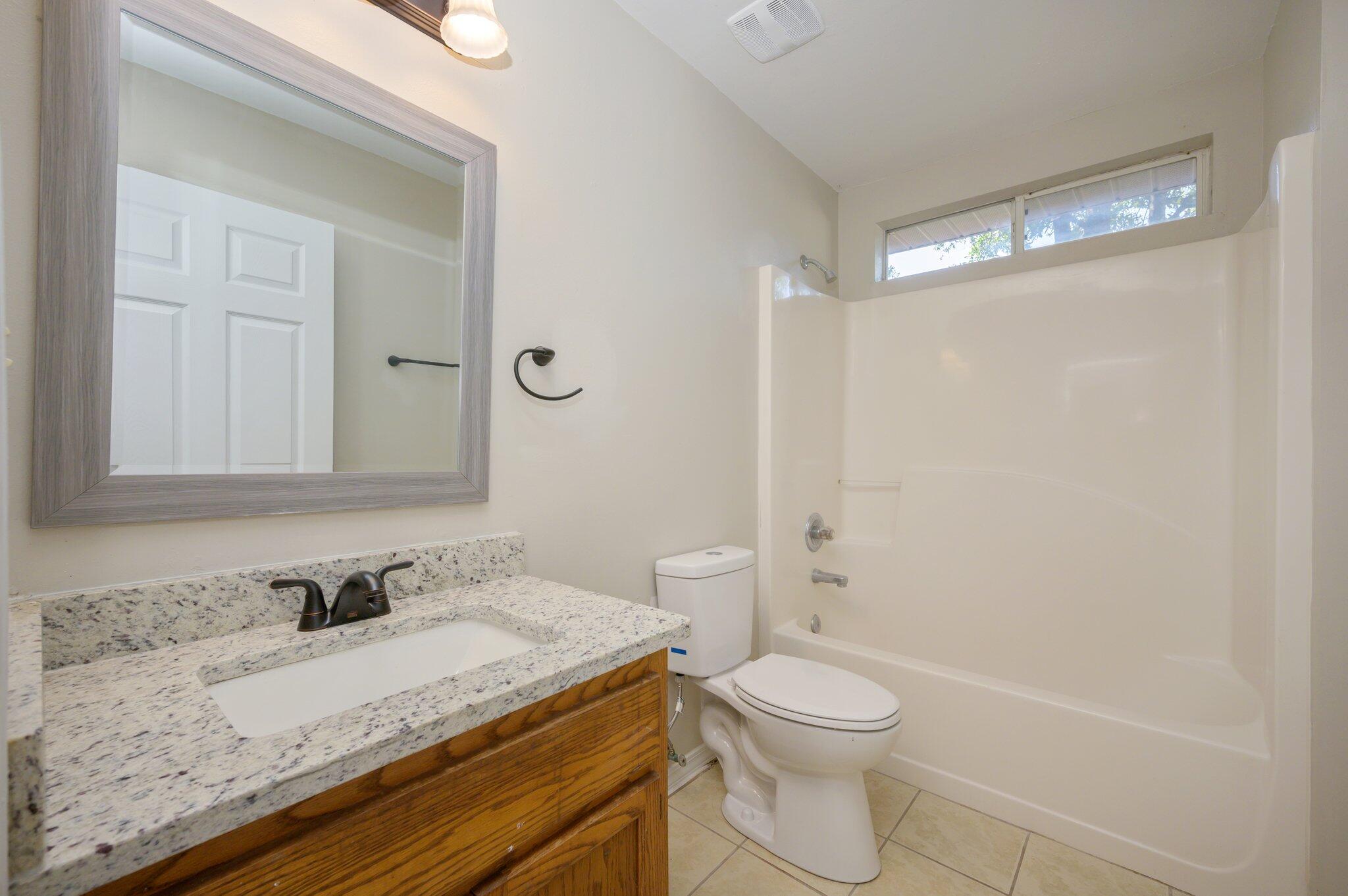 502 Hyde Park Drive Crestview, FL 32539 - Photo 20 of 35 a bathroom with a granite countertop sink toilet a mirror and shower