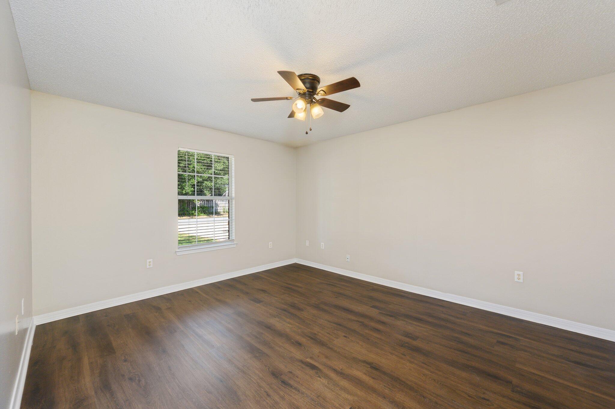 502 Hyde Park Drive Crestview, FL 32539 - Photo 23 of 35 an empty room with wooden floor and windows