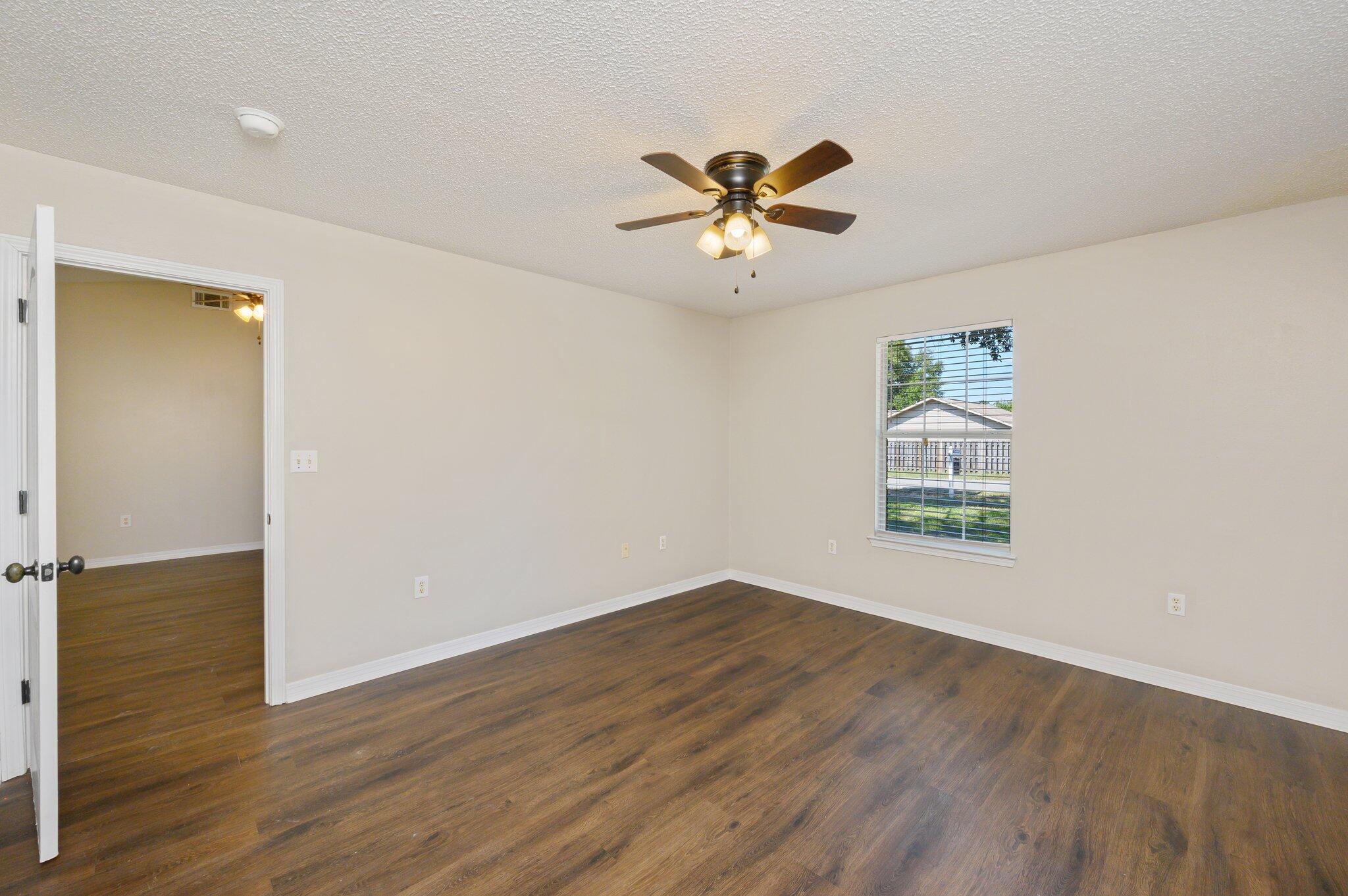 502 Hyde Park Drive Crestview, FL 32539 - Photo 24 of 35 a view of an empty room with wooden floor and a window