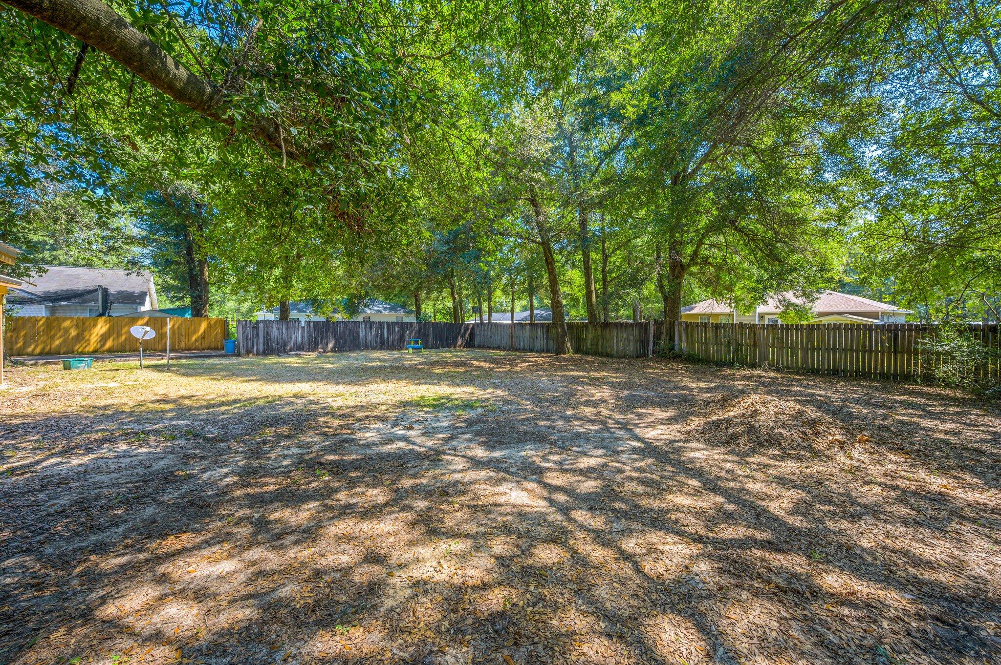 502 Hyde Park Drive Crestview, FL 32539 - Photo 35 of 35 a view of a backyard with large trees and wooden fence