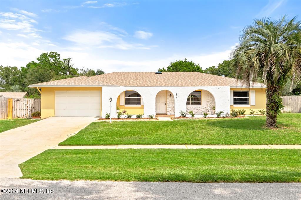 a view of a white house with a yard