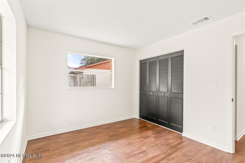 968 Espinado Avenue St. Augustine, FL 32086 - Photo 19 of 36 a view of an empty room with wooden floor and a window