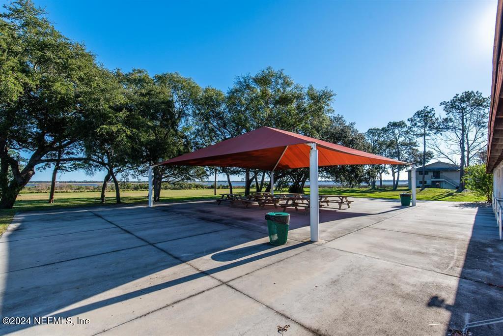 968 Espinado Avenue St. Augustine, FL 32086 - Photo 33 of 36 a patio with a table and chairs under an umbrella
