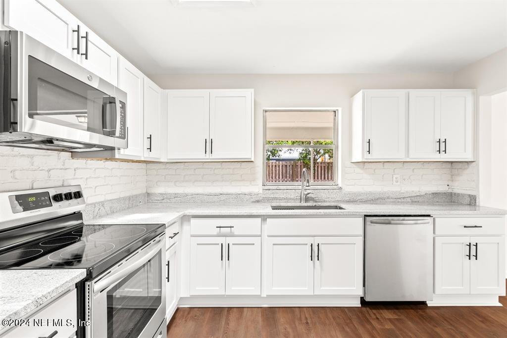 968 Espinado Avenue St. Augustine, FL 32086 - Photo 4 of 36 a kitchen with white cabinets sink and stainless steel appliances