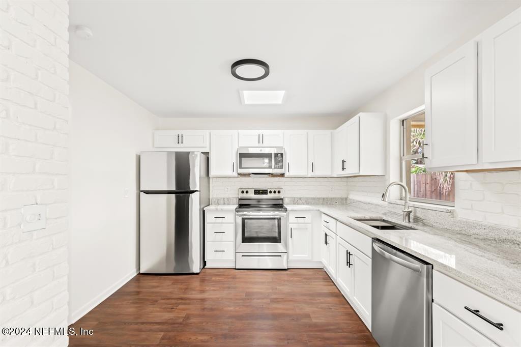 968 Espinado Avenue St. Augustine, FL 32086 - Photo 6 of 36 a kitchen with a refrigerator sink and cabinets