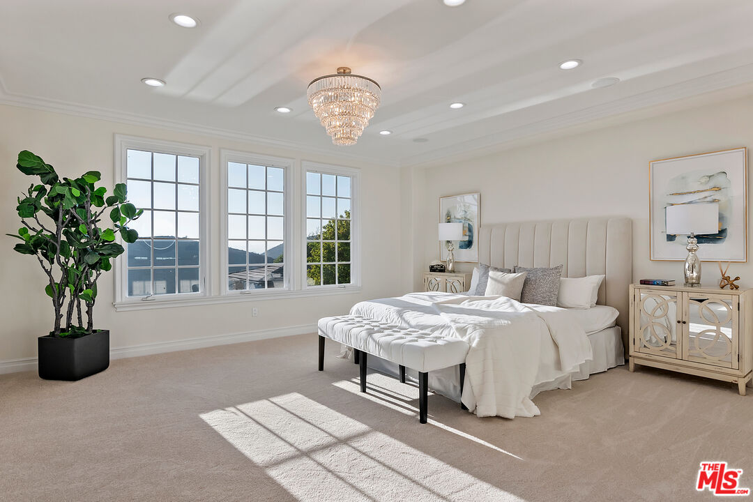 25430 Prado De Azul Calabasas, CA 91302 - Photo 20 of 51 a spacious bedroom with a bed and a chandelier
