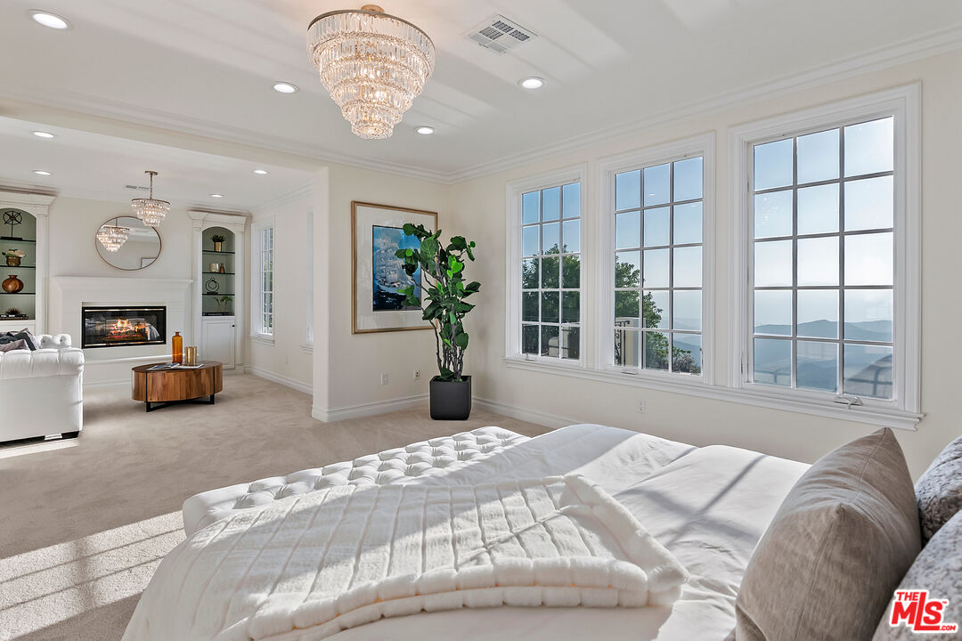 25430 Prado De Azul Calabasas, CA 91302 - Photo 22 of 51 a spacious bedroom with a bed mirror and a large window