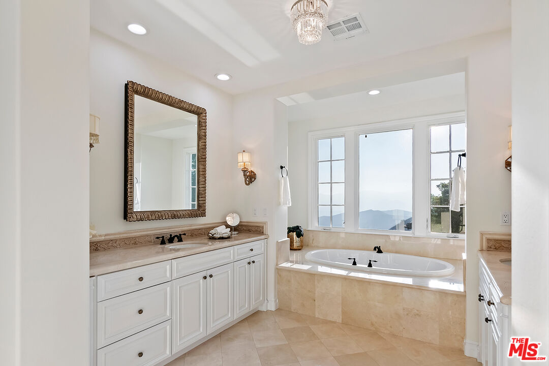 25430 Prado De Azul Calabasas, CA 91302 - Photo 25 of 51 a spacious bathroom with a double vanity sink bathtub large mirror and window