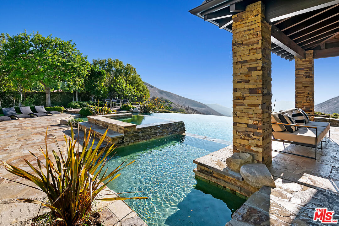 25430 Prado De Azul Calabasas, CA 91302 - Photo 41 of 51 a view of a patio with lawn chairs under an umbrella
