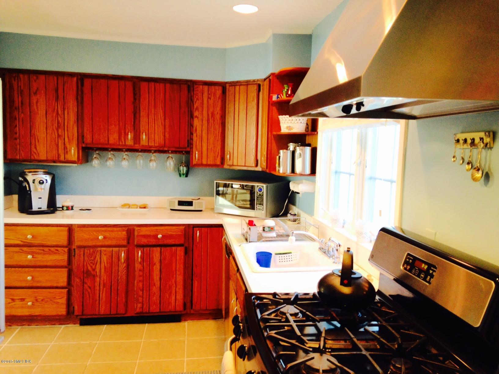 16 Orchard Street Cos Cob, CT 06807 - Photo 10 of 24 a utility room with stainless steel appliances a stove a sink and a refrigerator