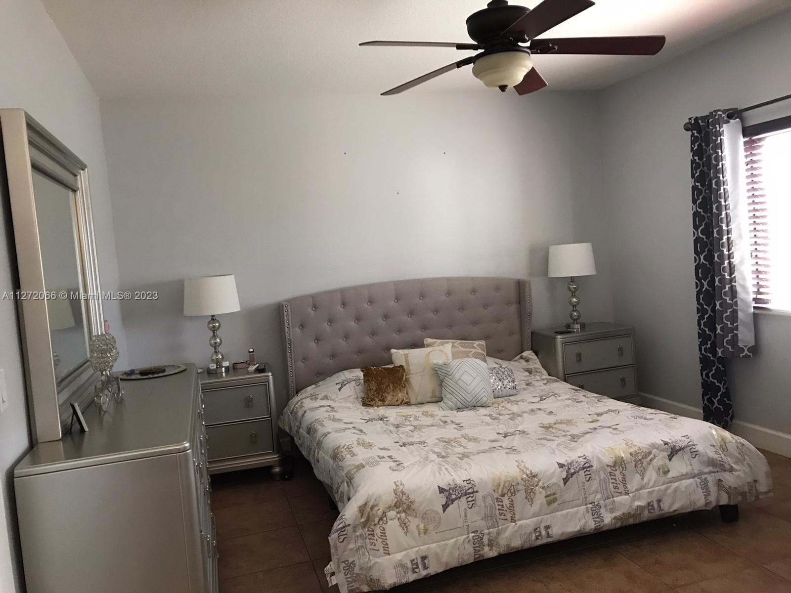 11115 West Okeechobee Road, Unit 176 Hialeah Gardens, FL 33018 - Photo 4 of 12 a bedroom with a bed and a refrigerator