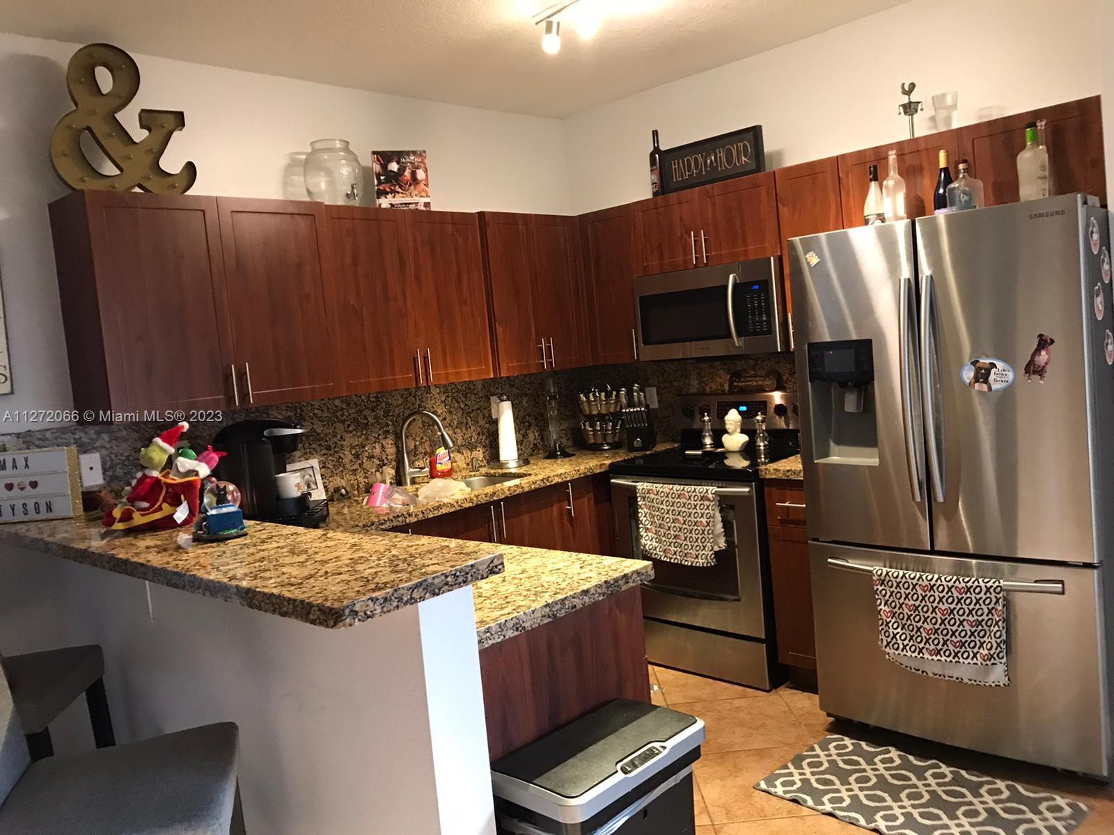 11115 West Okeechobee Road, Unit 176 Hialeah Gardens, FL 33018 - Photo 5 of 12 a kitchen with a refrigerator and a stove top oven