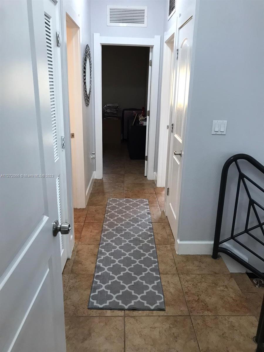 11115 West Okeechobee Road, Unit 176 Hialeah Gardens, FL 33018 - Photo 6 of 12 a view of a hallway with wooden floor and staircase