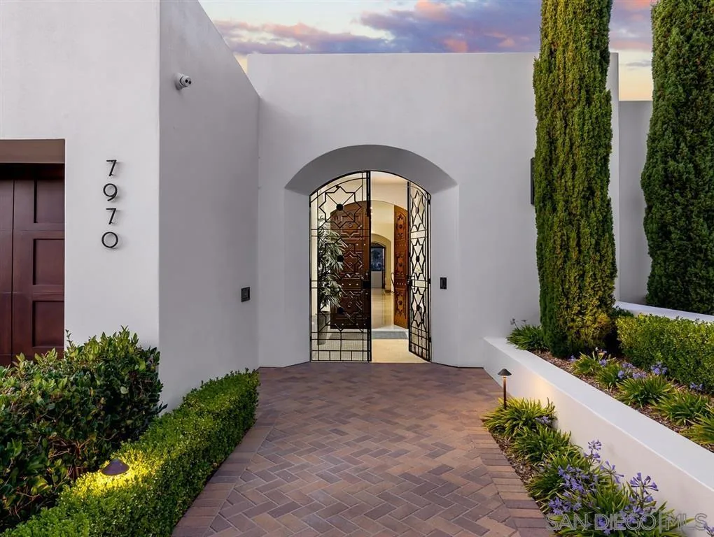 a view of a entryway door with flower plants