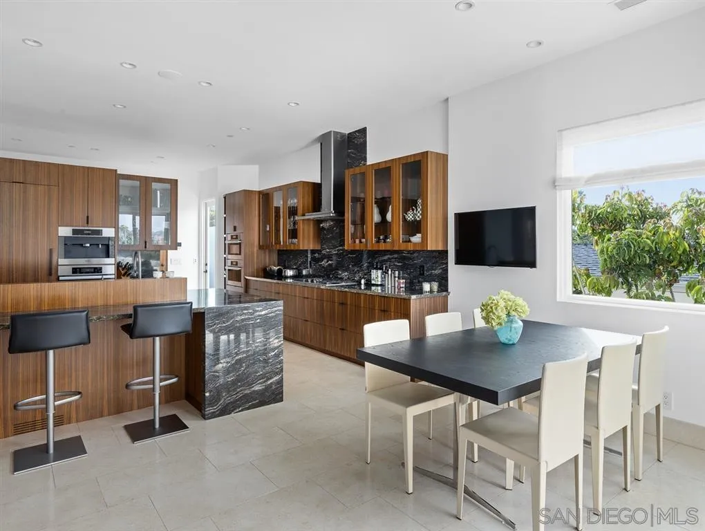 7970 Roseland Drive La Jolla, CA 92037 - Photo 13 of 23 a kitchen with stainless steel appliances kitchen island granite countertop a sink and a white cabinets