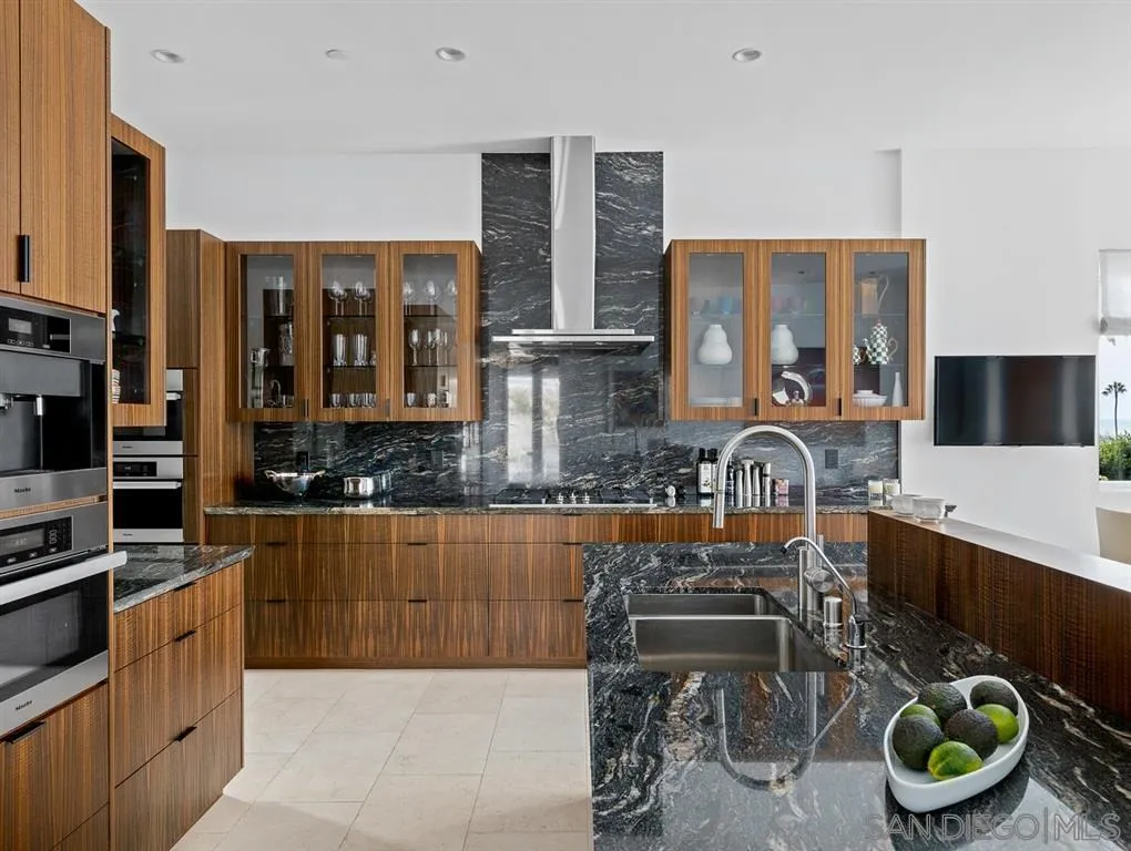 7970 Roseland Drive La Jolla, CA 92037 - Photo 15 of 23 a kitchen with furniture a kitchen island stainless steel appliances and wooden cabinets