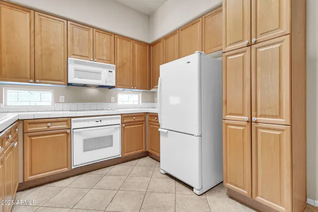 a large kitchen with a stove a refrigerator and a sink
