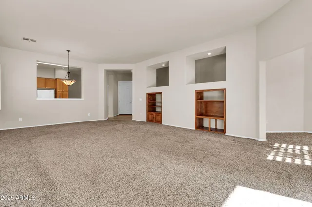 an empty room with windows and chandelier