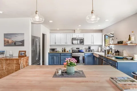a kitchen with kitchen island granite countertop stainless steel appliances lots of counter top space cabinets and a sink