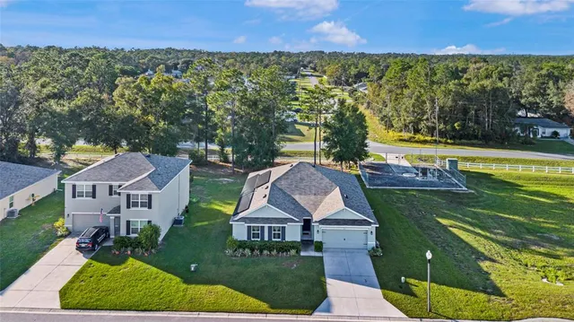 an aerial view of a house with a garden and lake view